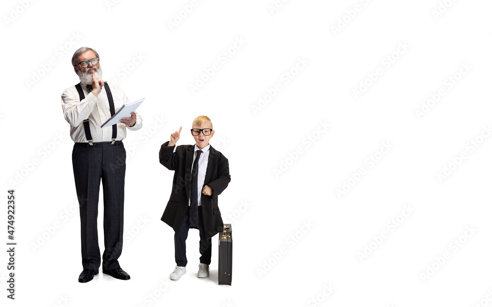 Cute little boy, kid businessman in huge jacket suit and young bearded business man isolated on white studio background. Cute little boy, kid businessman in huge jacket suit and young bearded business man isolated on white studio background.