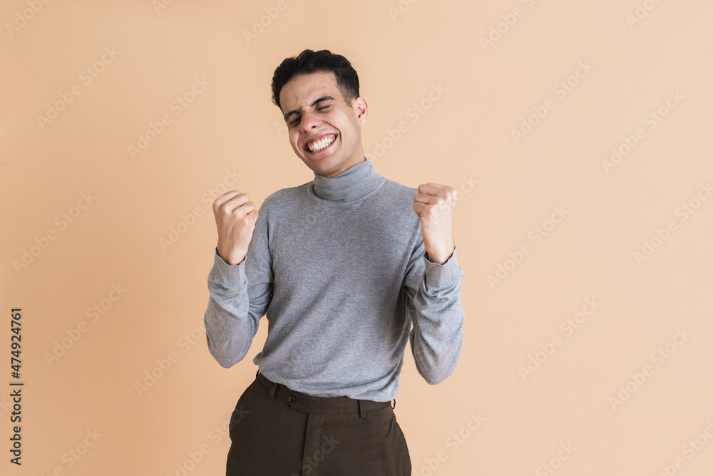 Young middle eastern man smiling while making winner gesture Young middle eastern man smiling while making winner gesture