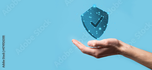 Businessman hold low poly polygon shield with a tick icon.Secure Access System Concept.Business Financial Warranty for Investment.antivirus concept.Technology security.Protection network,safe data.