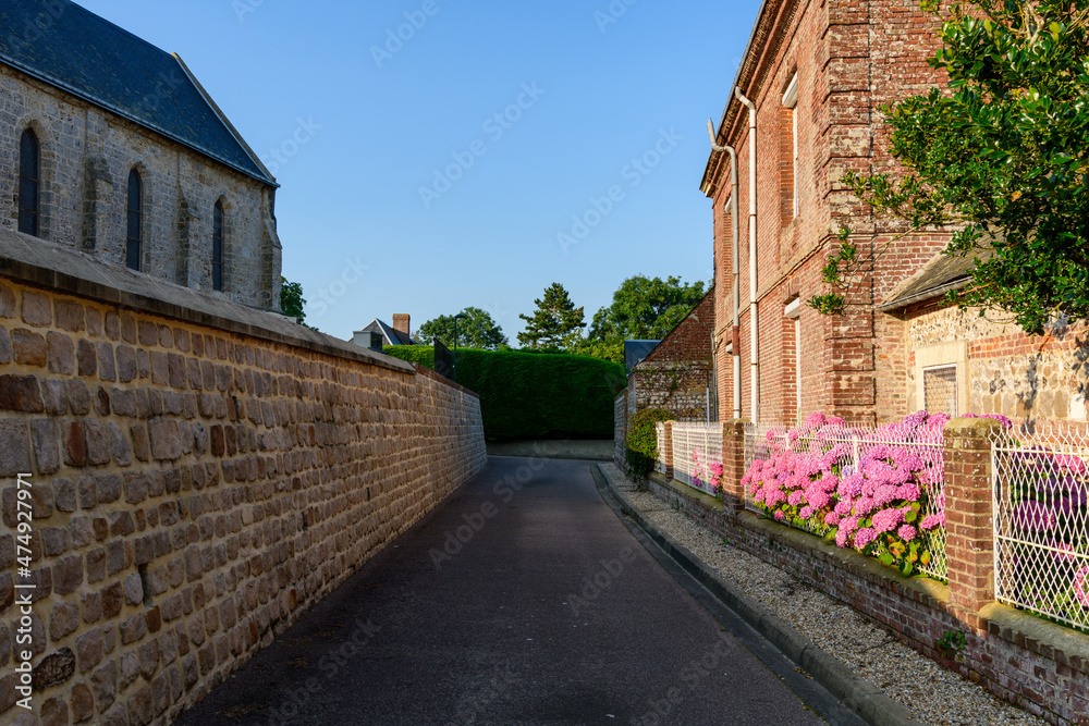 An alley in the traditional French village of Saint Sylvain in Europe, France, Normandy, Seine Maritime, in summer on a sunny day.