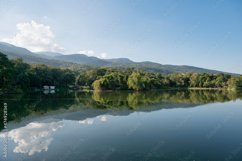 View of Ang Kaew reservoir with mountain and blue sky reflection on sunny day