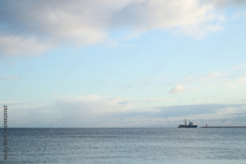 Open sea. Ship boat in the middle of the sea. Cloudy cloudy weather. Water waves. Sun at sea.