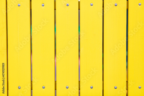 close-up of a yellow wooden fence. the street