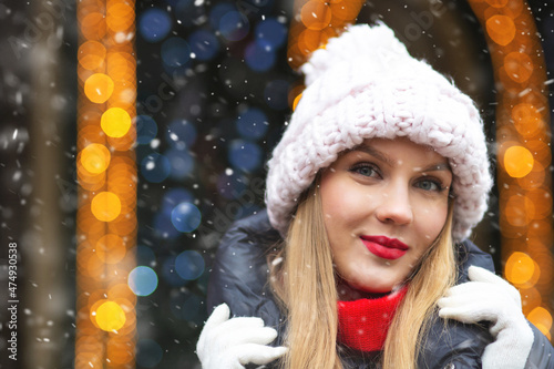 Attractive lady walking at the winter fair with snowflakes