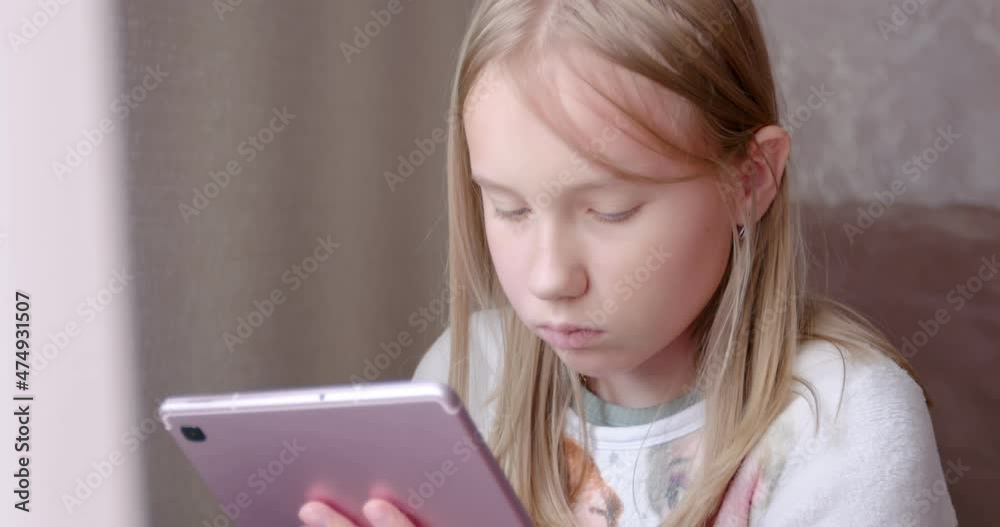 Teenager girl draws on the tablet. Kid child girl holding digital tablet. Online virtual class. Teenager learning at home. Teenager girl draws on the tablet. Kid child girl holding digital tablet. Online virtual class. Teenager learning at home.