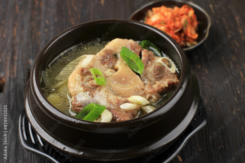 Close Up Sop Buntut Gori Gomtang (Sokkori Gomtang) or Korean Beef Oxtail Stew  Soup, Served in the Black Korean Bowl with Kimchi and Sliced Green Onion