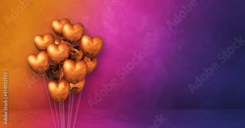 Copper heart shape balloons bunch on a rainbow wall background. Horizontal banner.