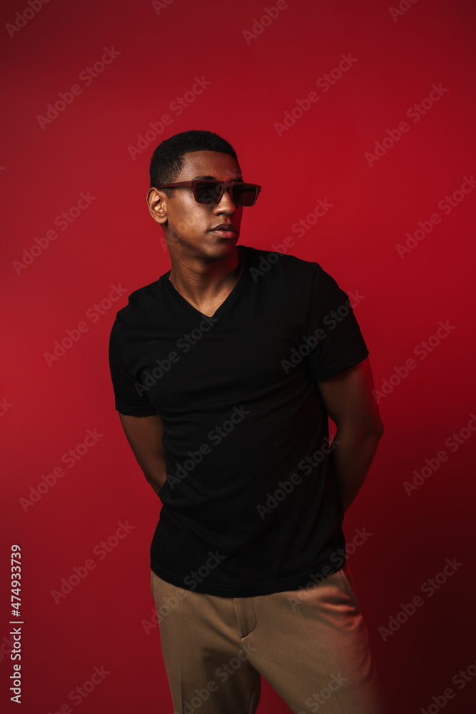 Young black man wearing sunglasses posing and looking aside Young black man wearing sunglasses posing and looking aside