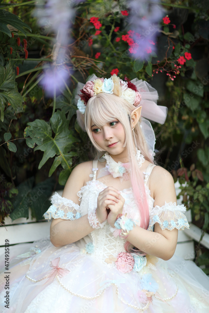 Beautiful young woman with white lolita dress with flowers garden Japanese fashion Beautiful young woman with white lolita dress with flowers garden Japanese fashion