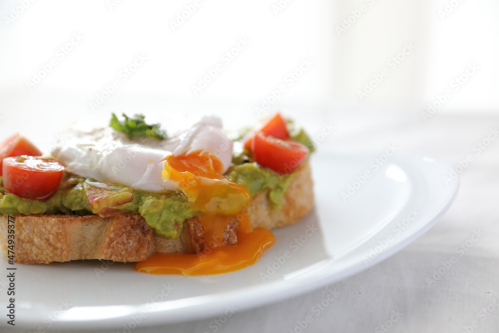 Poached eggs with avocado on toast in white background Poached eggs with avocado on toast in white background