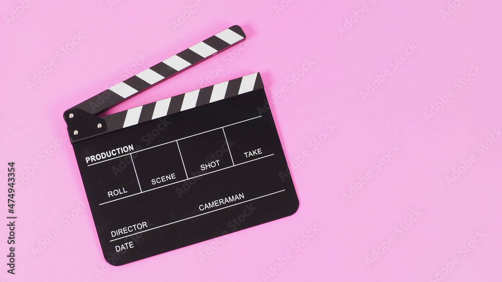Black Clapper board or movie slate on pink background..
