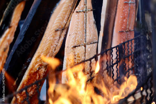 Flames of fire roasting filet pieces of salmon in the background. Christmas market in Luxembourg photo