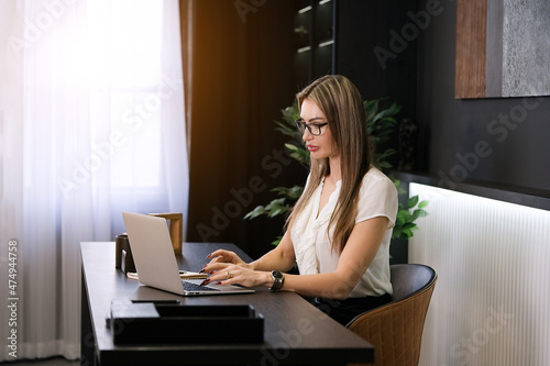 Businesswoman working on laptop in her workstation in modern office