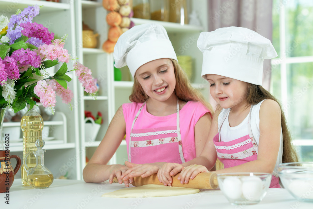 Cute little girls in hats making dough Cute little girls in hats making dough