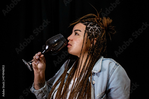 beautiful woman with braces drinks red wine in a glass