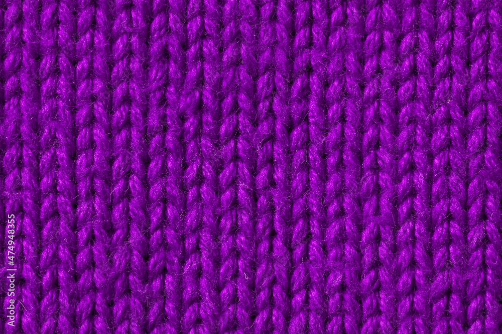 Background. Knitted fabric made of violet Merino wool. Large weave. Pigtail pattern. Background. Knitted fabric made of violet Merino wool. Large weave. Pigtail pattern.