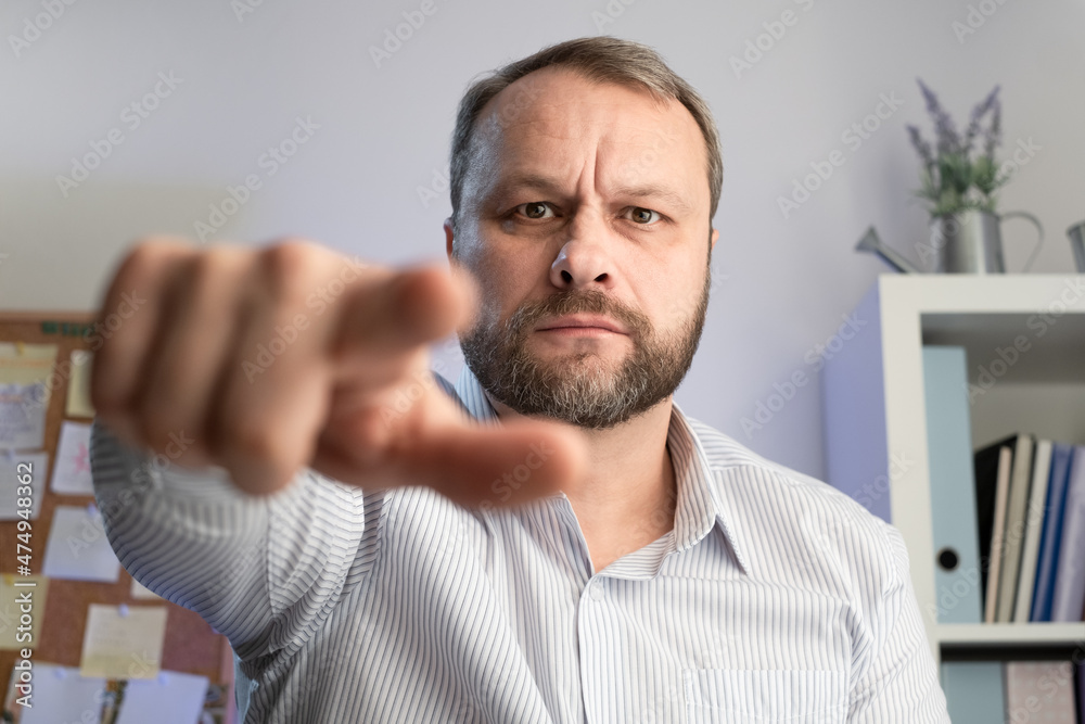 Serious Middle aged Man index forefinger pointing to camera in Home office. I chose you gesture concept. Serious Middle aged Man index forefinger pointing to camera in Home office. I chose you gesture concept.