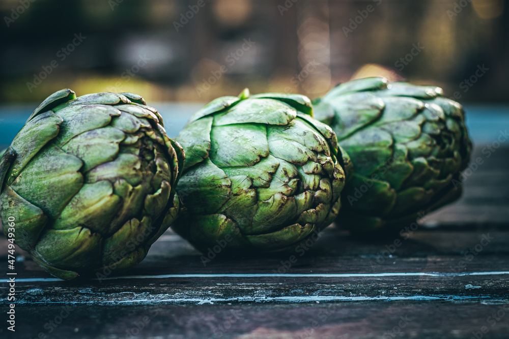 Fototapeta premium Several fresh artichokes, on the table. After picking from the vegetable garden