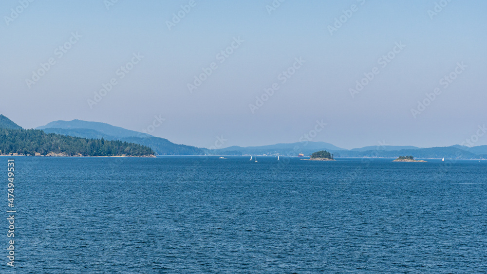 strait of Georgia between Vancouver and Victoria with small islands boats and blue sky