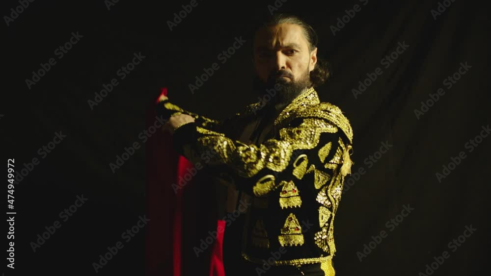 Male dancer or toreador imitating moves of matador bullfighter on black smoky background .  Man bullfighter dressed in bullfighting costume . Shot on ARRI Alexa cinema camera in Slow Motion 