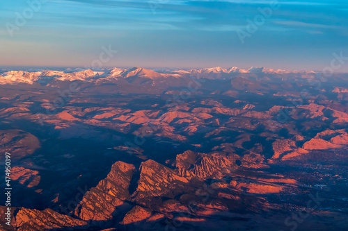 Aerial view of the Rocky Mountains covered by snow on sunset