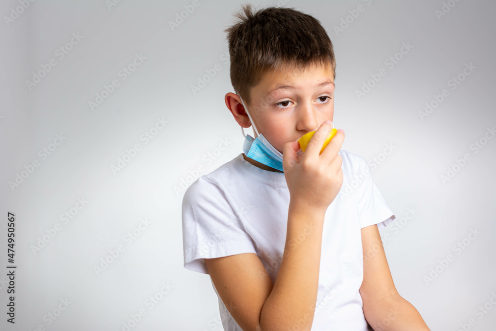 Anosmia or smell blindness, loss of the ability to smell, one of the possible symptoms of covid-19, infectious disease caused by corona virus. Boy Trying to Sense Smell of a Lemon Anosmia or smell blindness, loss of the ability to smell, one of the possible symptoms of covid-19, infectious disease caused by corona virus. Boy Trying to Sense Smell of a Lemon