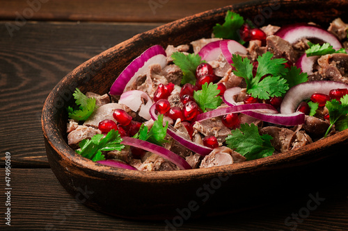 Traditional Georgian cuisine, Kuchmachi, chicken giblets, in ketsi, on a wooden table, close-up, horizontal, no people, photo