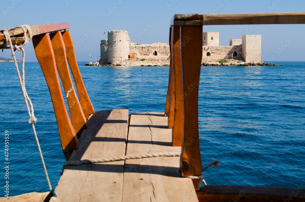 Obraz premium Picturesque landscape view ruins of ancient Kizkalesi (Maiden's Castle). View from touristic boat. Mediterranean Sea, Mersin,Turkey. Natural composition. Famous touristic place and travel destination