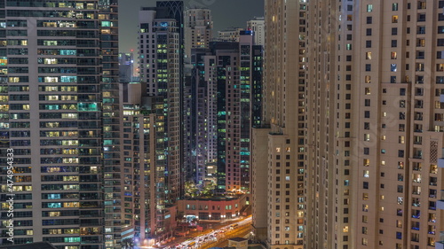 Overview to JBR and Dubai Marina skyline with modern high rise skyscrapers waterfront living apartments aerial night timelapse