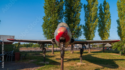 Fototapeta Naklejka Na Ścianę i Meble -  Training aircraft L-29. Supersonic jet aircraft for practicing mastery in flight. Installed in the Victory Park in Nizhny Novgorod. Against the backdrop of blue sky and green trees.
