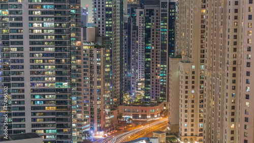 Overview to JBR and Dubai Marina skyline with modern high rise skyscrapers waterfront living apartments aerial all night timelapse