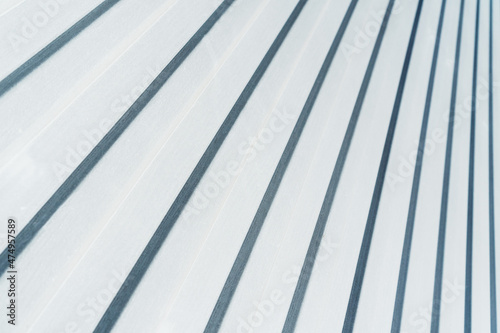 Metal siding with a corrugated pattern of white color diagonally.