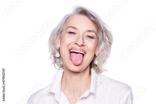 Shot of a beautiful mature woman having fun and teasing sticking out her tongue isolated on white background