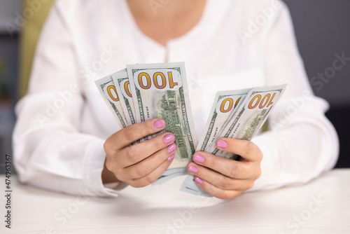 Woman cashier counting one hundred dollar bills. Businesswoman hands recounting american paper currency. Female hands holding 100 dollar banknotes. Save money concept. Dirty money