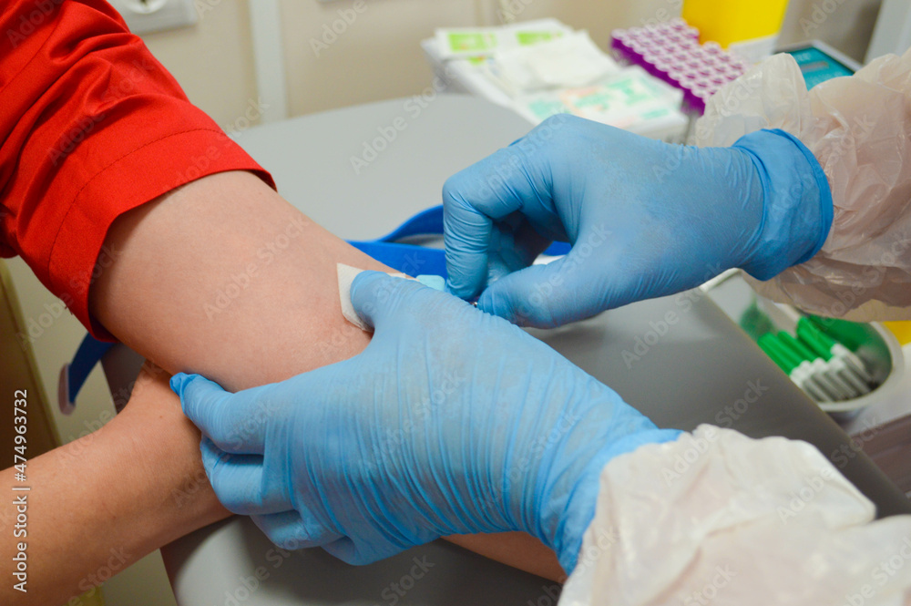 Doctor using syringe takes blood from patient arm Doctor using syringe takes blood from patient arm