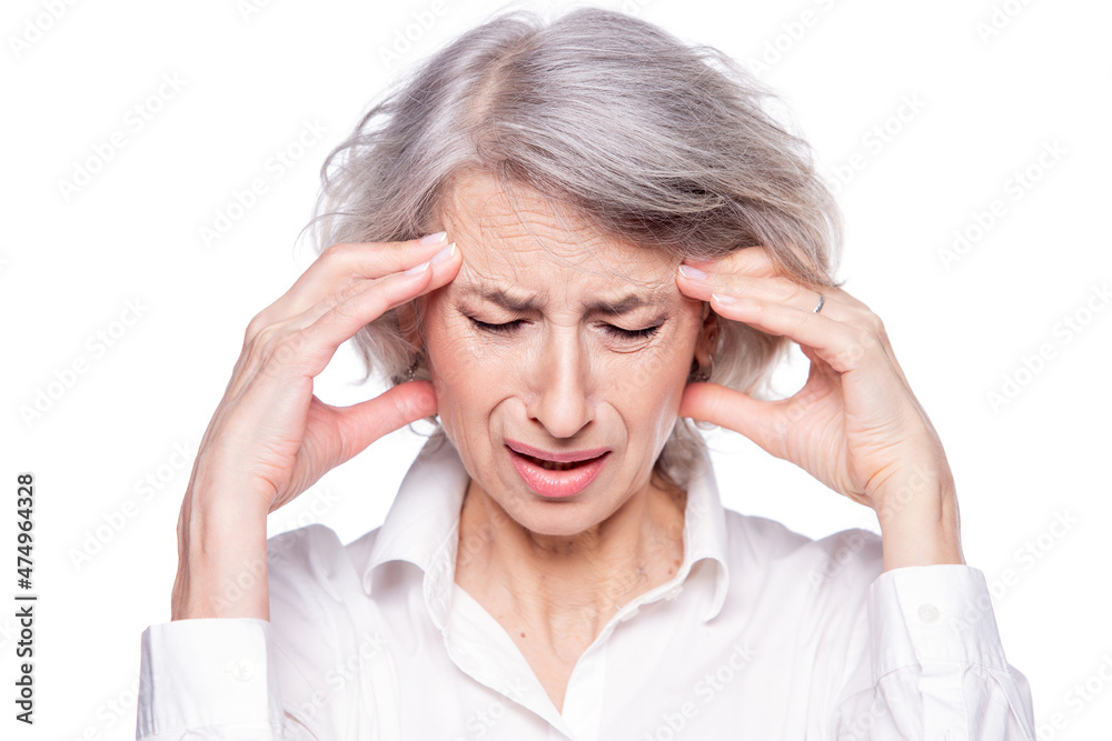 Portrait of an old but modern trendy woman suffering from a headache or migraine holding her head in her hands with a desperate expression and screaming from pain isolated on white background Portrait of an old but modern trendy woman suffering from a headache or migraine holding her head in her hands with a desperate expression and screaming from pain isolated on white background
