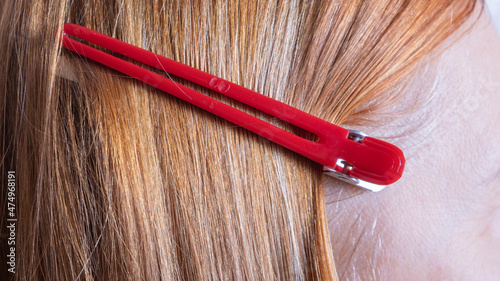red barrette in the hair of a woman's head