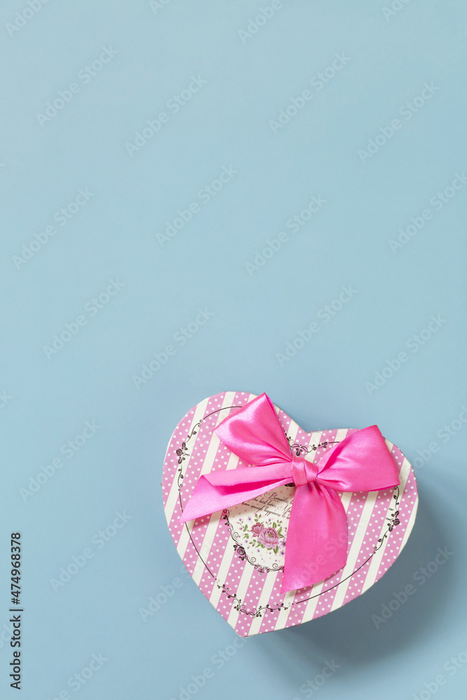 Valentine's day concept with heart gift box on a blue background, minimal layout. Top view flat lay ​with copy space.