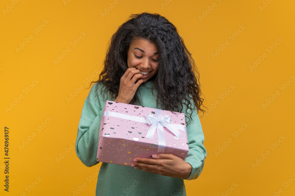 Fototapeta premium Studio portrait of suprised cute girl accepting unexpected present