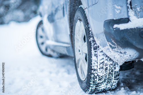 Closeup view of winter tires on a road covered with snow in cold freeze winter months.