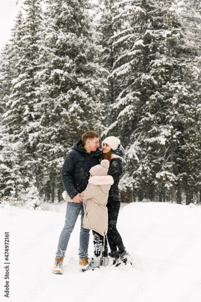 Happy family have fun in winter forest. Mother, father and dauther playing with snow.Family concept
