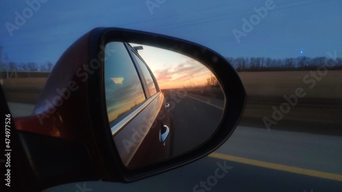 sunset in the car rearview mirror