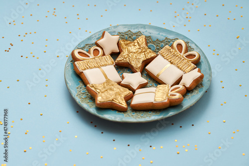 Christmas gingerbread cookies on a blue plate and blue background. Copy space for text. Flat lay. Winter holidays background.