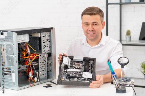 Wallpaper Mural computer repair shop. professional services. a man repairs motherboard Torontodigital.ca