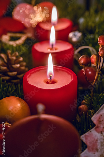 Three burning red candles on Advent wreath