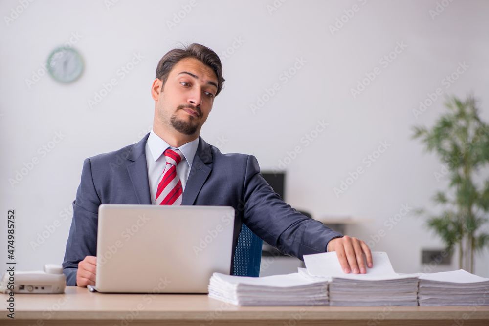 Young male employee sitting at workplace Young male employee sitting at workplace