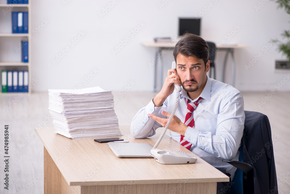 Young male employee sitting at workplace