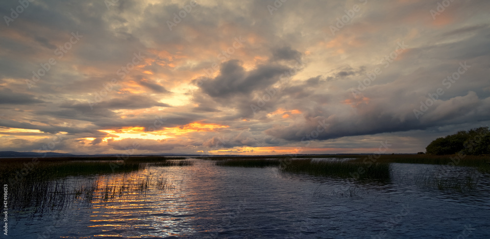 Dramatic cloudy sunset scenery of Corrib lake with mountains in the background at in Galway, Ireland Dramatic cloudy sunset scenery of Corrib lake with mountains in the background at in Galway, Ireland
