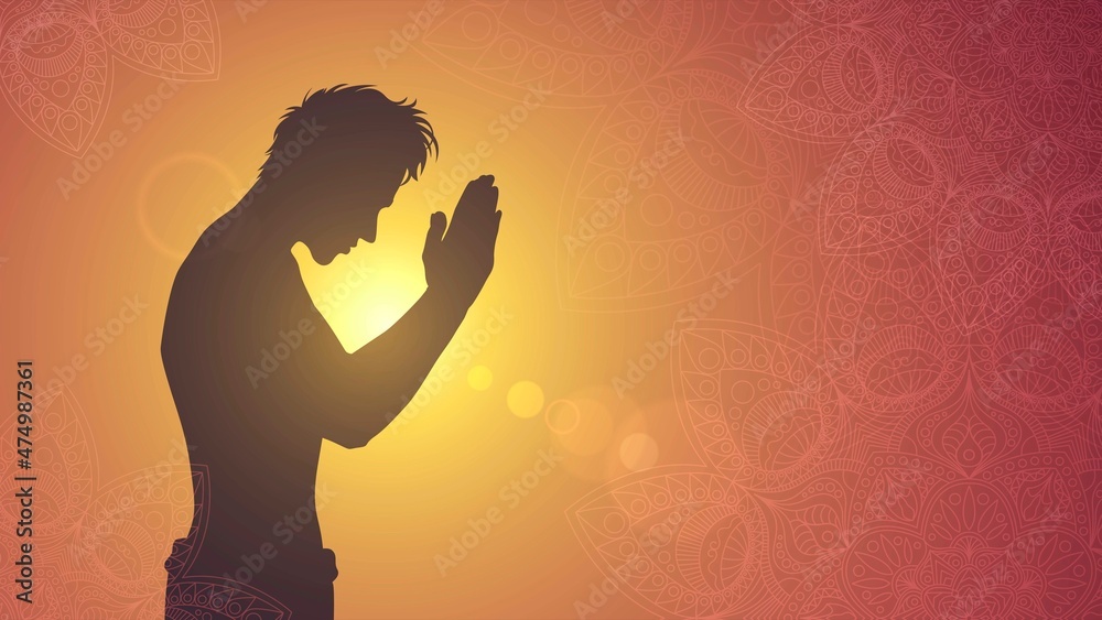 Silhouette of a praying man on the background of the sunset sun
