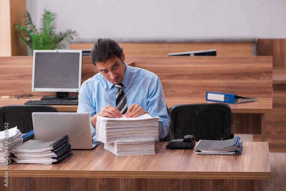 Young male employee unhappy with excessive work